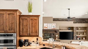 Eine moderne Küche mit Holzschränken, Edelstahlgeräten, einer Marmorarbeitsplatte und einem eingebauten Kamin.