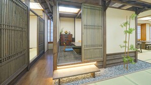 Un interior japonés tradicional con suelo de tatami, puertas correderas y un pequeño jardín interior.
