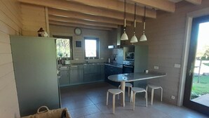 Une cuisine moderne avec un coin repas comprenant une table et des chaises, un panier et une horloge murale.
