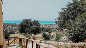 A stone pathway leading to a scenic overlook with views of the sea and surrounding vegetation. - Agriturismo Balcone Mediterraneo Camere (Ragusa)