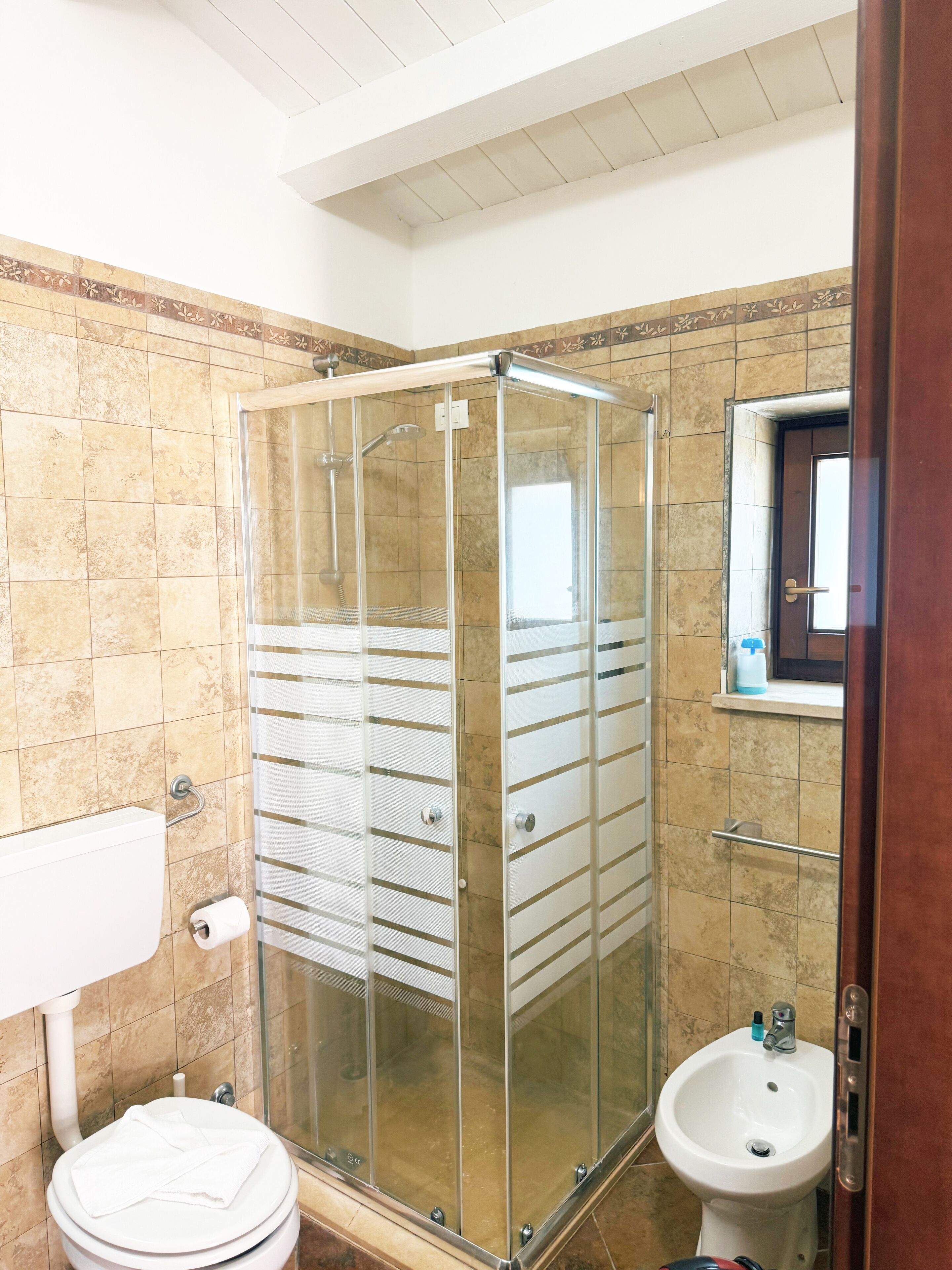 Ein Badezimmer mit einer Duschkabine, einer Toilette und einem Waschbecken.