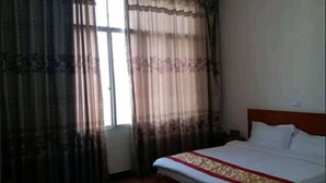 Un dormitorio con cama, cortinas y ventana.