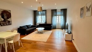 Un salón amplio con sofá, mesa de centro y comedor.