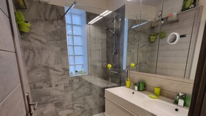 A modern bathroom with a shower, a toilet, and a sink.