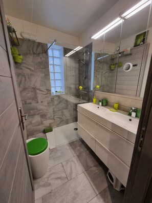 A modern bathroom with a shower, a toilet, and a sink.