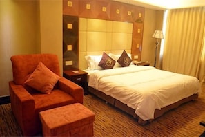 A hotel room with a bed, a nightstand, a chair, and a lamp. - Shiji Huayuan Leisure Club (Huizhou)