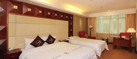 Quarto de hotel com duas camas, cabeceira de madeira, uma escrivaninha e uma cadeira.