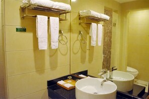 Un baño con dos lavamanos, un espejo, toalleros y una cortina de ducha.