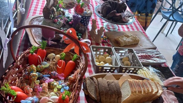 Una mesa de buffet con diversos alimentos y una cesta de huevos de Pascua.