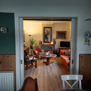 A living room with a fireplace, a television, and a dining area with a table and chairs. - De Mast bij Fort Vechten,house in old farmhouse, on the countryside near Utrecht (Bunnik)