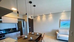 A modern kitchen with a dining area, a refrigerator, a microwave, and a coffee maker. - Edificio Liv P.Verde Apto 1108 (Maceió)