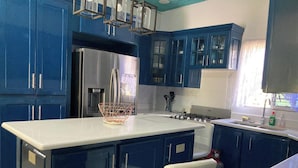 A kitchen with blue cabinets, a white countertop, and stainless steel appliances. - 1 Bedroom Blissful Retreat - A/C & Private Garden (Gravel Hill District)