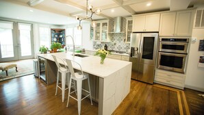 A modern kitchen with a central island, stainless steel appliances, and a decorative backsplash.