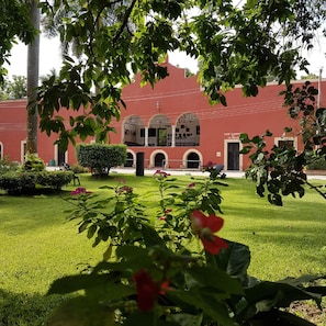 Stunning historic building with a central arched window and beautifully manicured lawn.