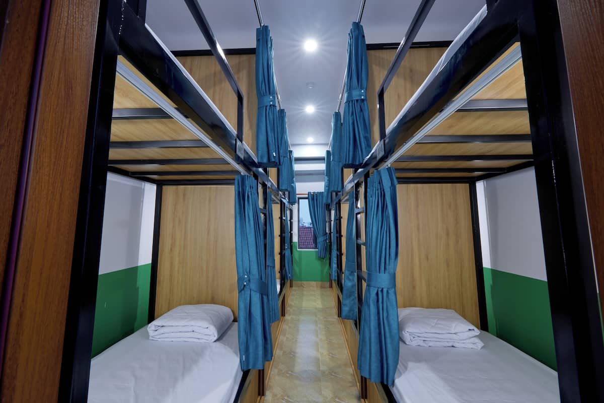 A train compartment with two beds, wooden walls, and curtains.