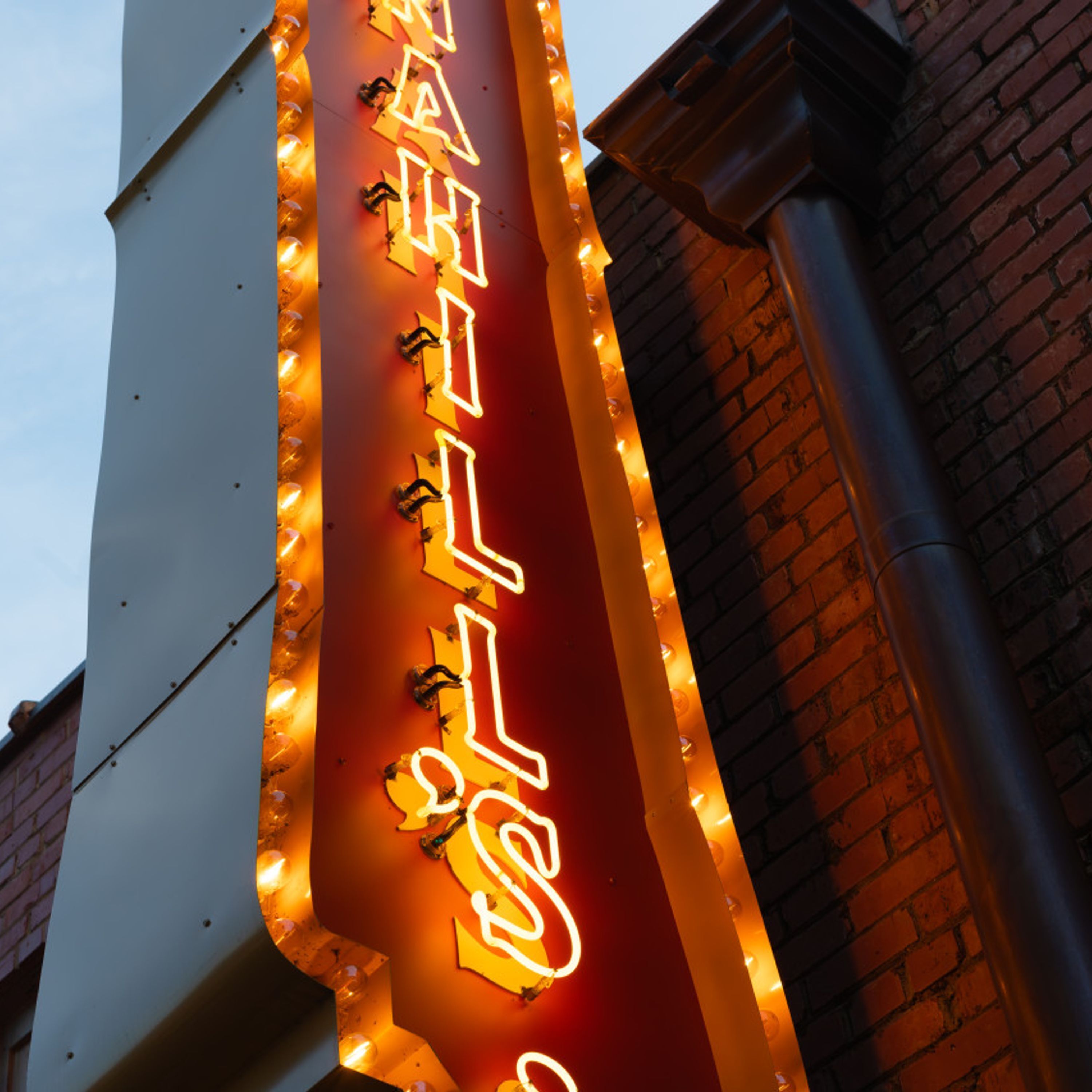 A neon sign with illuminated letters on a building facade.