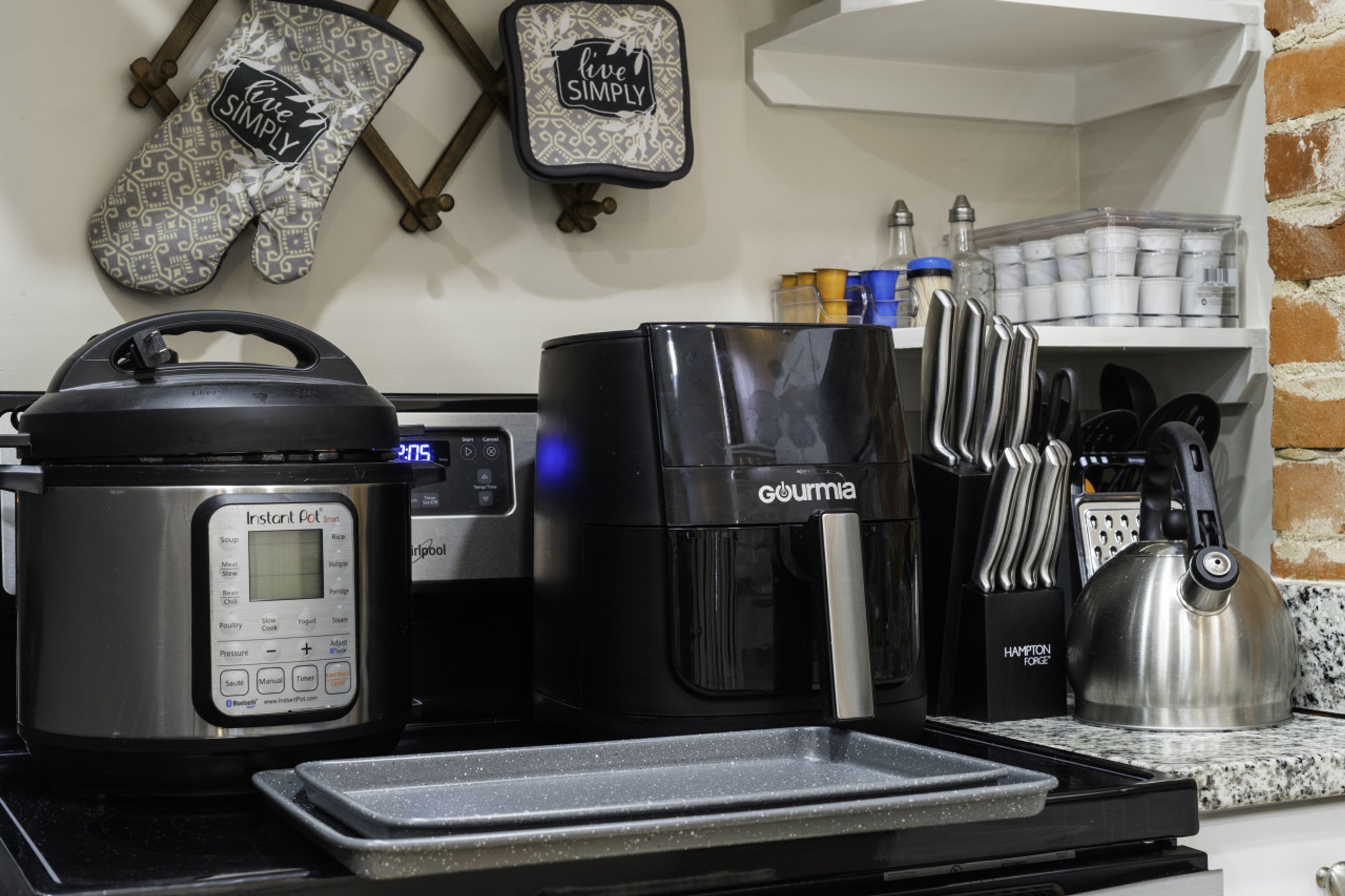 A kitchen with a coffee maker, a rice cooker, and a kettle.