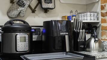 A kitchen with a coffee maker, a rice cooker, and a kettle.