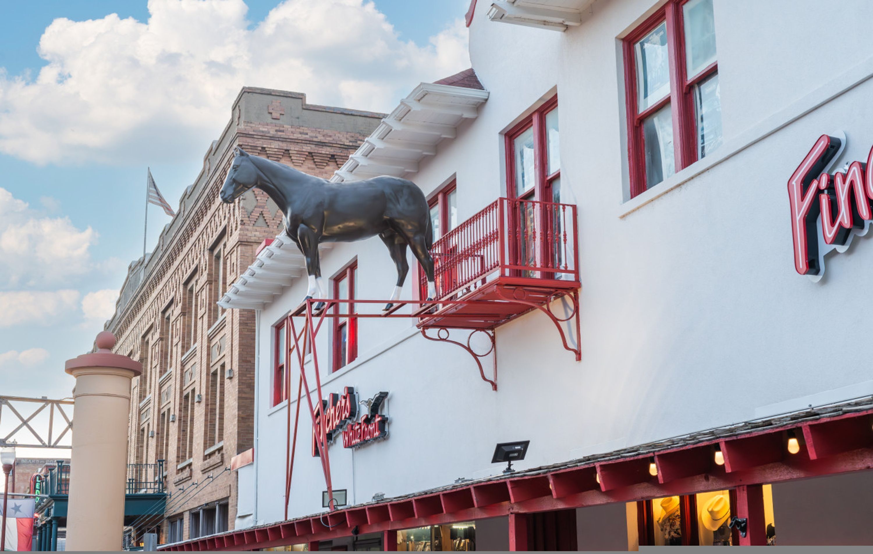 A building with a horse statue, a balcony, and a sign that reads "The Ranch."