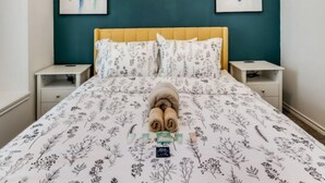 A bedroom with a bed, two nightstands, a window, and abstract art on the walls. - Family Business Retreat King Bed Top Amenities (Euless)