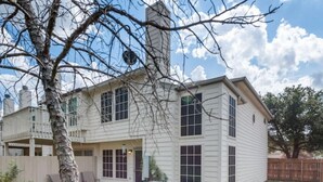 A two-story house with a covered patio and a fenced backyard. - Family Business Retreat King Bed Top Amenities (Euless)