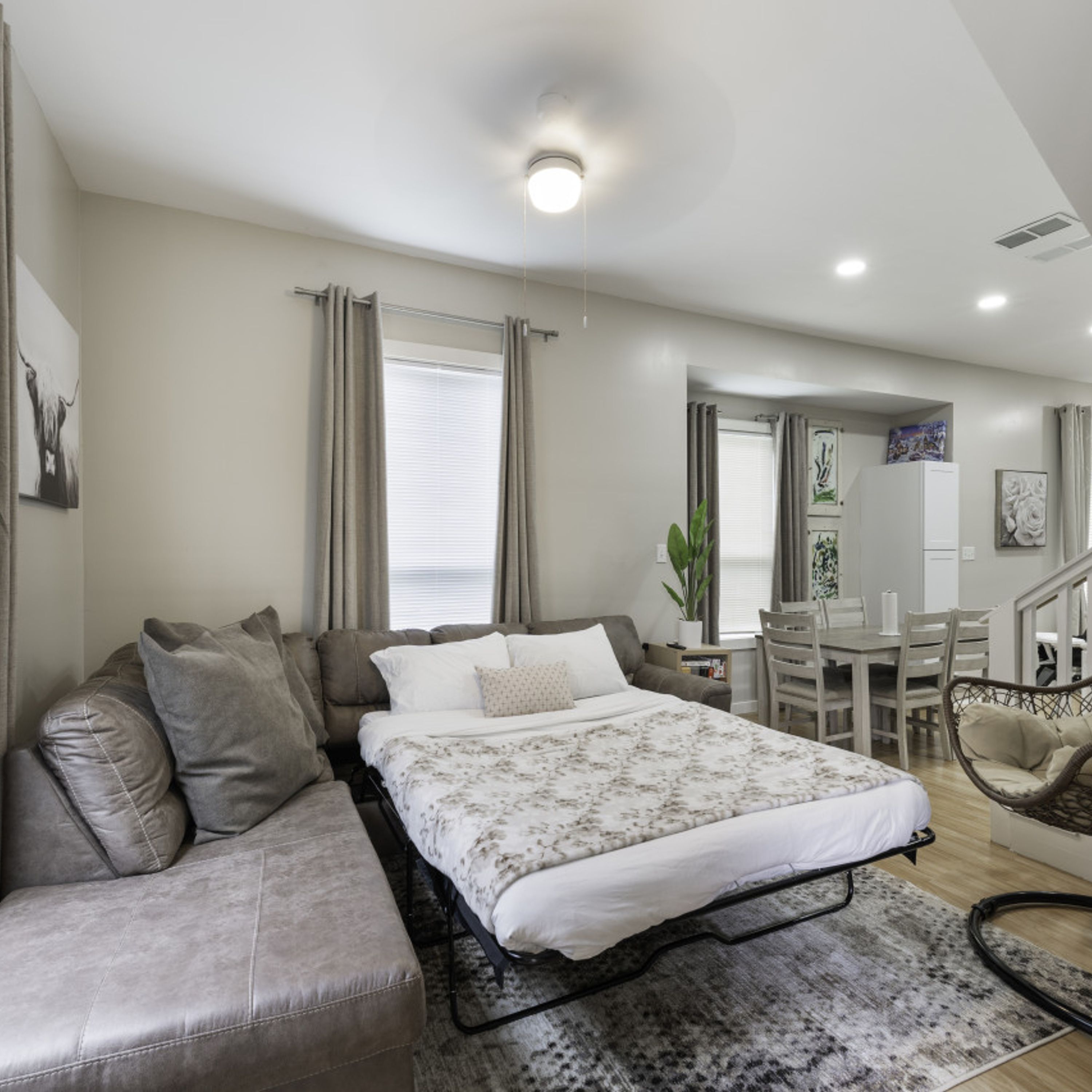 Een moderne slaapkamer met een bed, een bank en een eethoek.