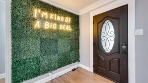 A wall with a green leafy texture and a neon sign that reads "I'M KIND OF A BIG DEAL." - Rare Exclusive Retreat Private Hot Tub King Bed (Arlington)