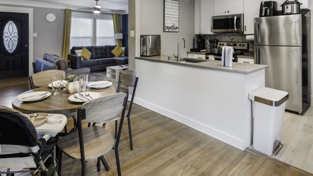 A modern kitchen with a central island, stainless steel appliances, and a dining area with a wooden table and chairs. - Rare Exclusive Retreat Private Hot Tub King Bed (Arlington)