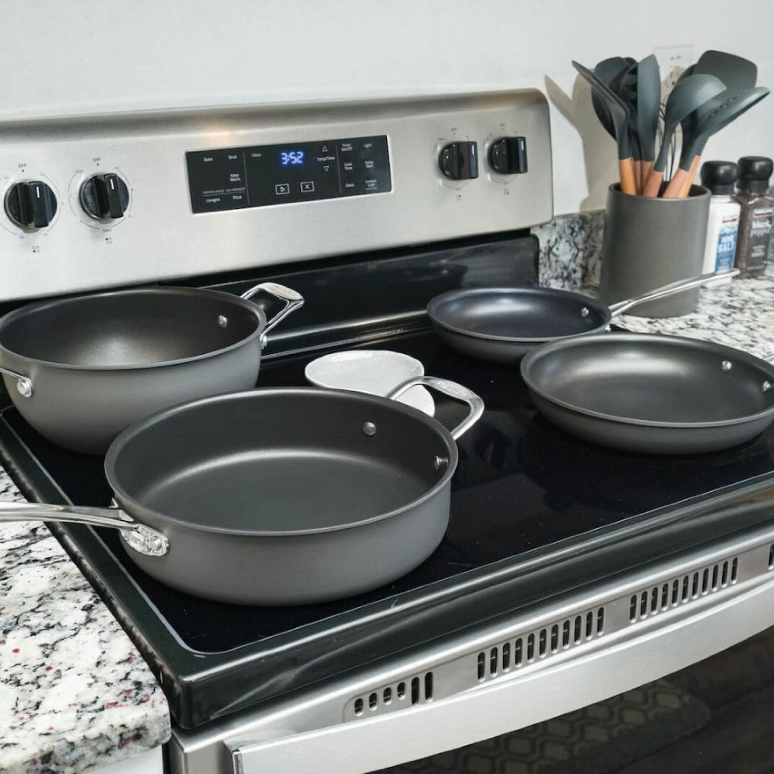 A kitchen with a stove, four pots, and a spice rack.