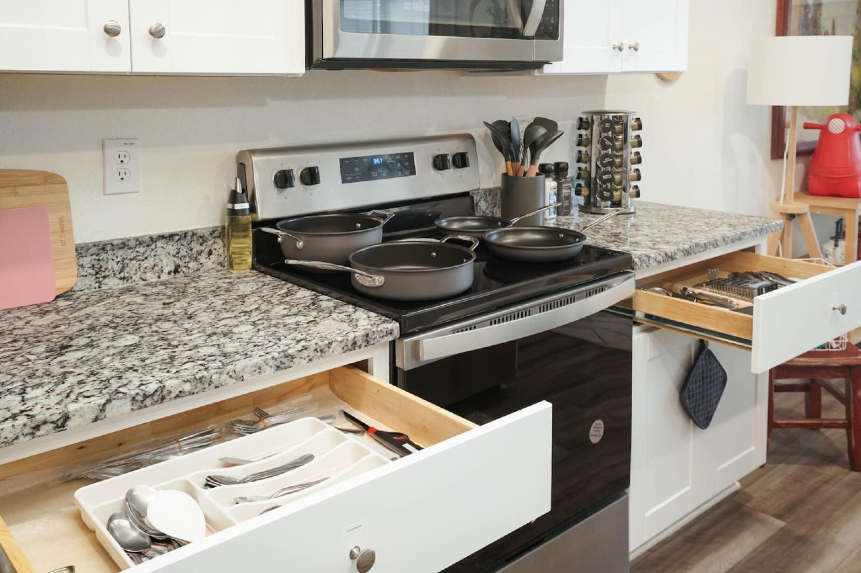 A kitchen with a granite countertop, stainless steel appliances, and a drawer organizer.