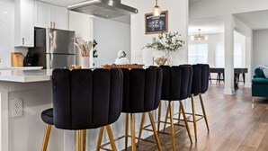 Una cocina moderna con una isla central, electrodomésticos de acero inoxidable y una lámpara colgante.