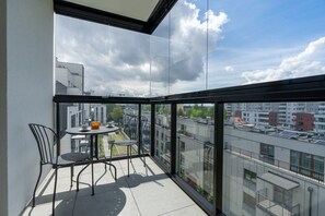 A balcony with a table and chairs, offering a view of the cityscape. - Warsaw Bemowo - Parking, Balcony & Workspace - by Rentujemy (Warszawa)