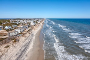 A coastal residential area with houses along the beach, clear skies, and calm ocean waves. - NEW! Prime Location @Beach Club -Tranquil Seascape (Corolla)
