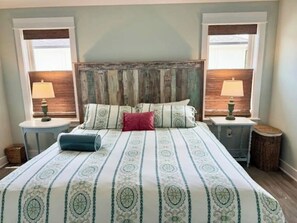 Une chambre à coucher avec un grand lit, deux tables de chevet et une tête de lit.