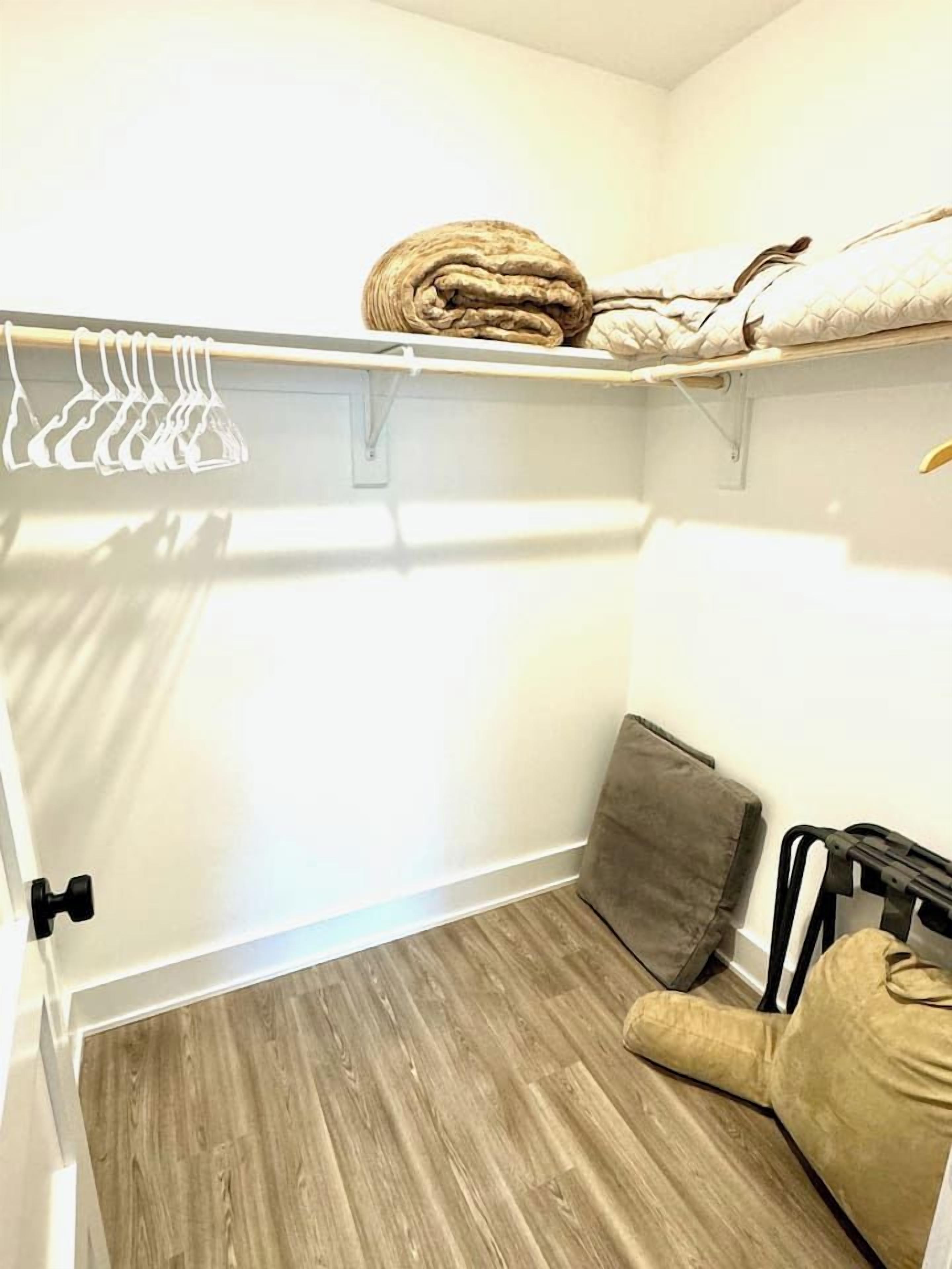 Ein kleines Zimmer mit Etagenbett, einer Sitzecke und einem Kleiderständer.