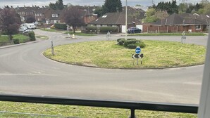 A residential street with houses, a roundabout, and a bicycle in the foreground. - Inviting 2-bed Apartment in Bushey (Bushey)