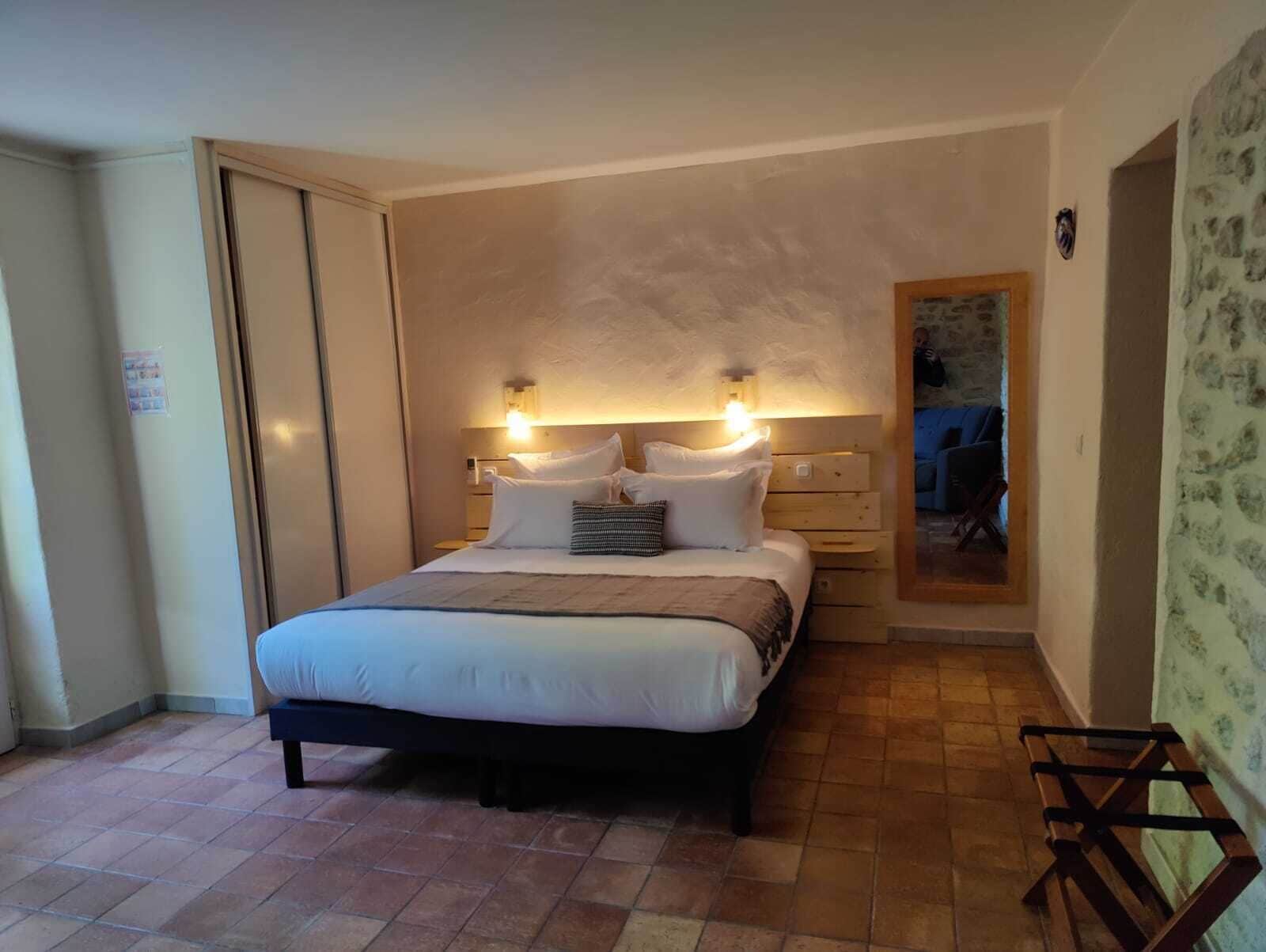 A bedroom with a bed, bedside tables, and a mirror.