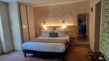 A bedroom with a bed, bedside tables, and a mirror.