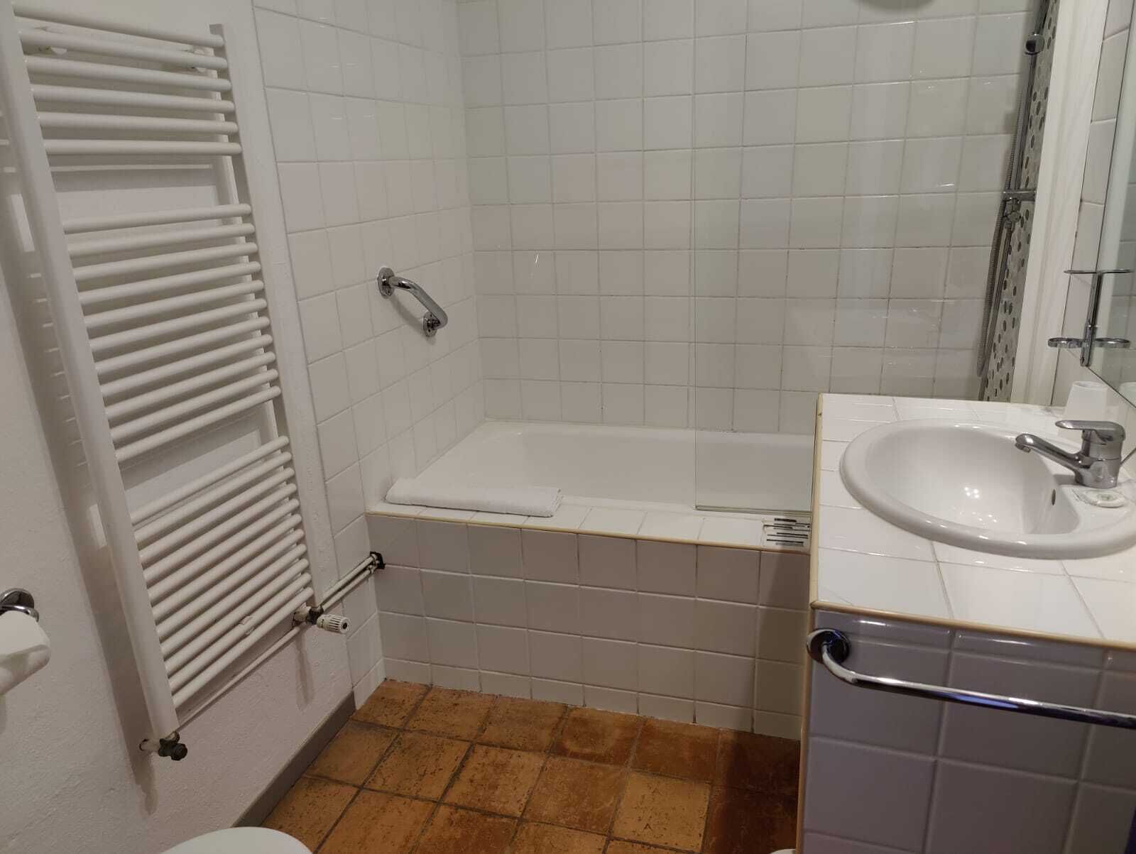 Un baño con bañera, lavamanos e inodoro.