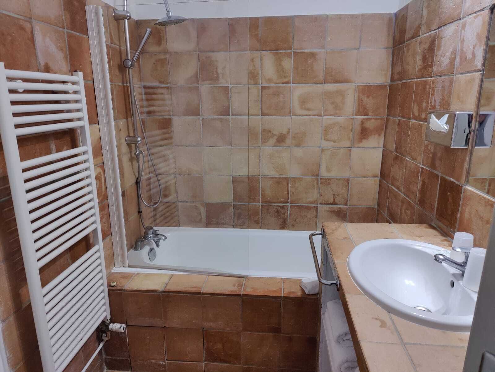 A bathroom with a bathtub, a shower, and a sink.