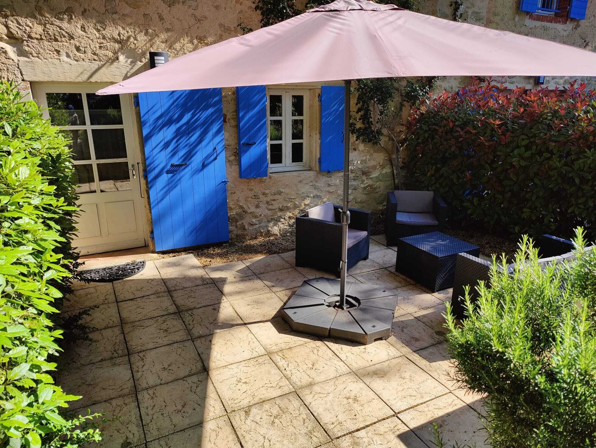 A patio area with outdoor furniture and a large umbrella.
