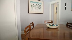 Ein Esszimmer mit einem Holztisch, vier Stühlen und einer Schüssel mit Snacks.