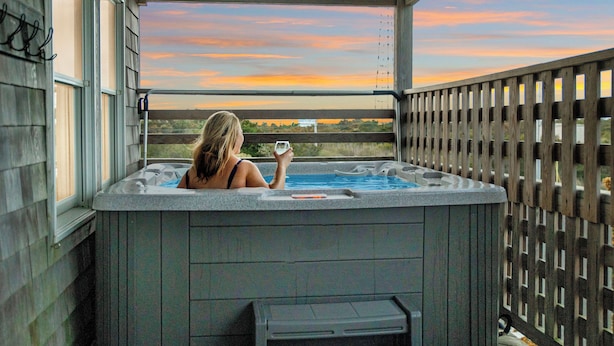 Un jacuzzi con vistas a la puesta de sol.