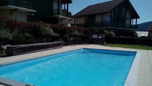 A rectangular swimming pool with clear blue water, surrounded by a tiled deck.