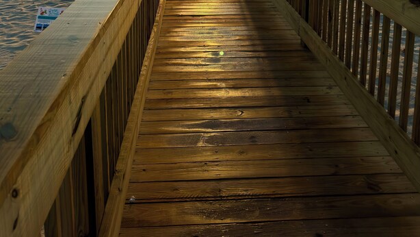 A wooden pier leading to a beach with the sun setting in the distance. - 🌴 Family Beach Retreat, Movie Theater, Game Room, Hot Tub, Near Ocean (Palm Coast)