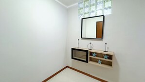 Een kamer met een spiegel, een plankje met decoraties in de vorm van sterren, en een raam met een rasterpatroon.