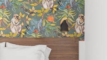 A bedroom with a bed, a nightstand, and a wall with a colorful mural.