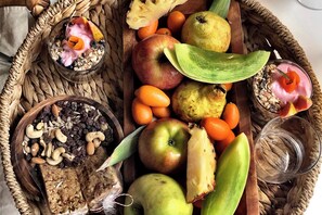 A wooden tray with fruits, nuts, and two glasses of a pink drink. - Refugio 31 (Partido de Tigre)