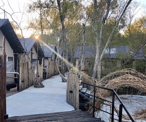 A wooden pathway leading to a row of cabins with a snowy ground. - Refugio 31 (Partido de Tigre)