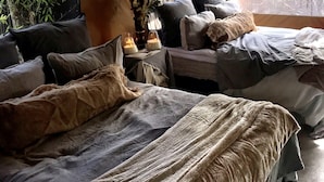 A tented accommodation with two beds, a table with candles, and a view of greenery outside. - Refugio 31 (Partido de Tigre)